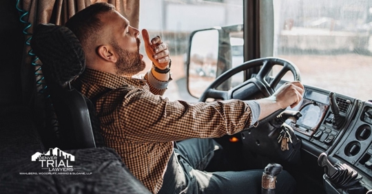 Truck driver yawning while driving.